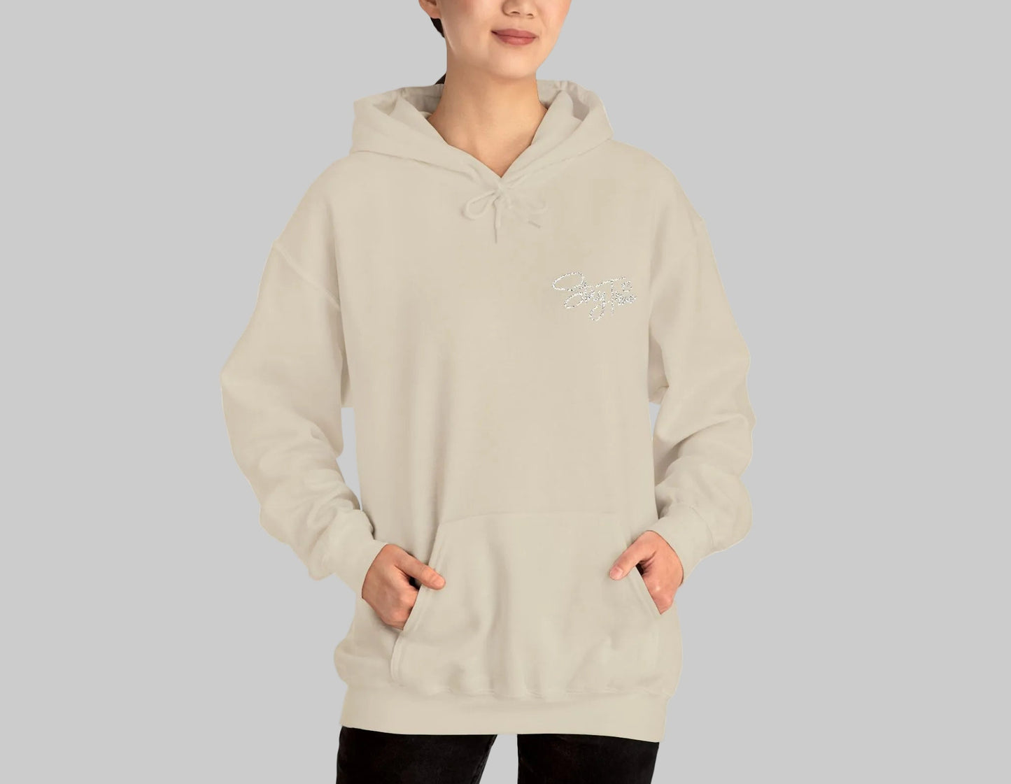 Person wearing a beige hoodie with a logo on a white background